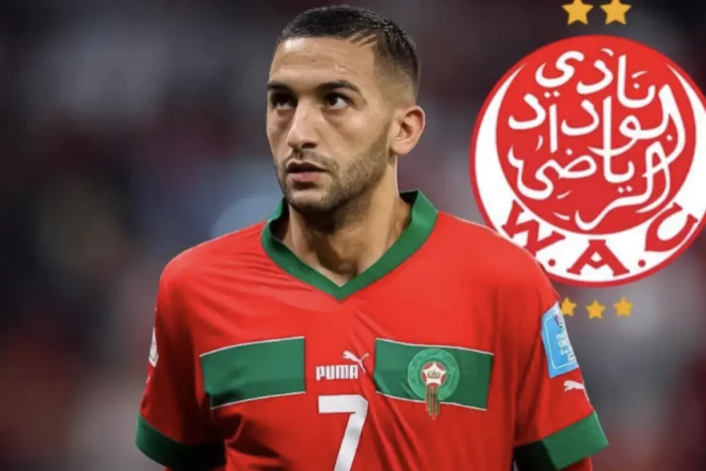 Hakim Ziyech wearing a Wydad Casablanca jersey on the pitch, with the club’s red and white logo in the background.